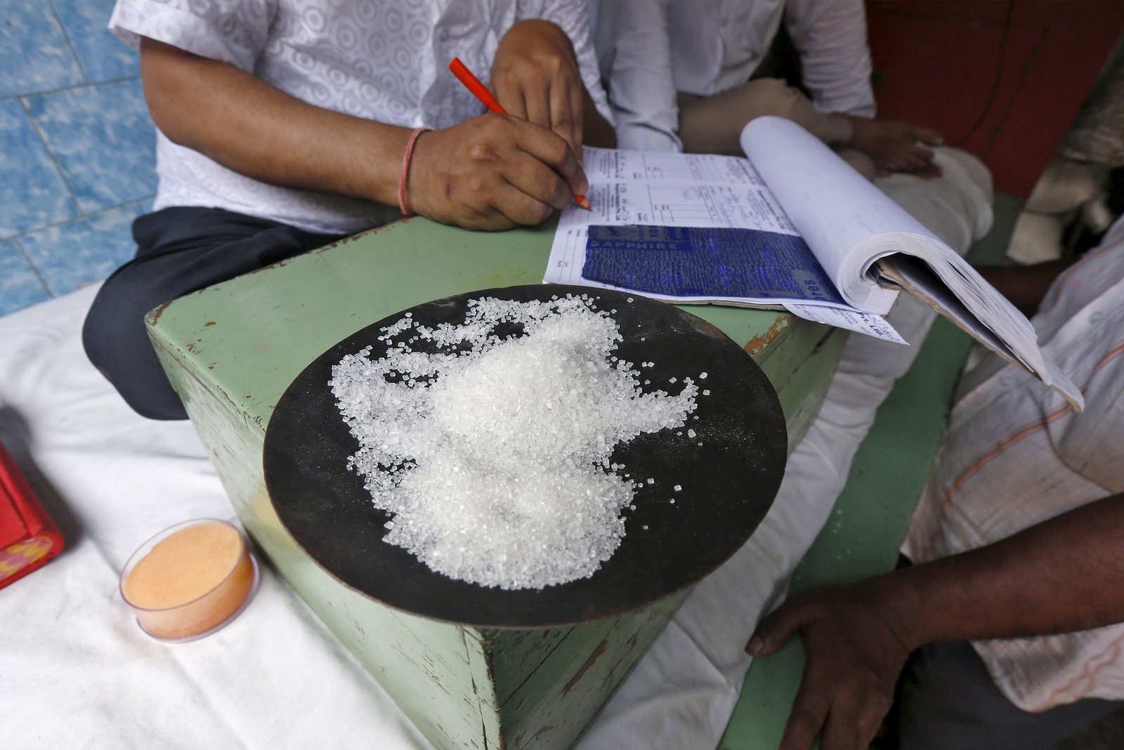 A sample of sugar crystals are seen on the desk of a trader at a wholesale market in Kolkata